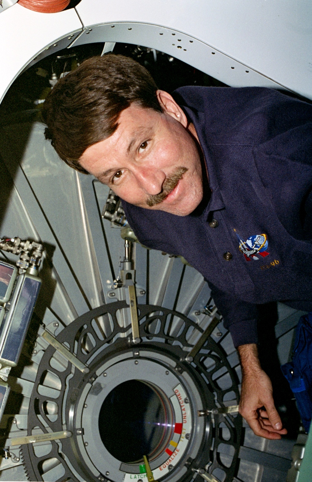 CDR Rominger beside one of the CBM hatches on the Node 1/Unity module