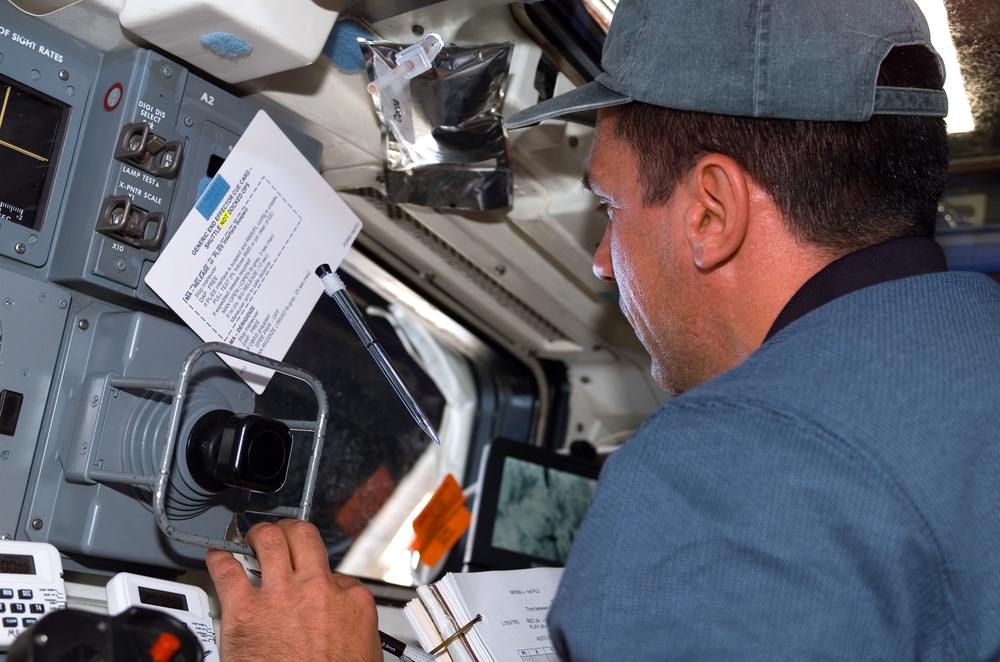 STS-116 Oefelein looks out window in the aft FD on Space Shuttle Discovery
