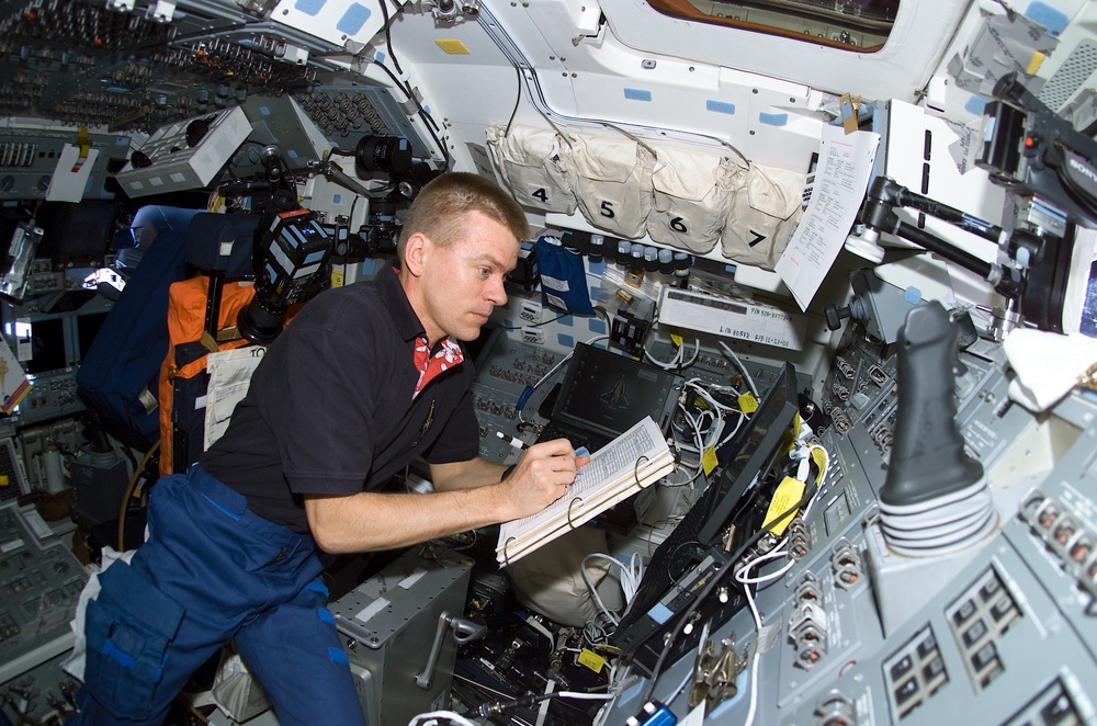 McCool takes notes on a checklist at a workstation on Columbia's AFD during STS-107