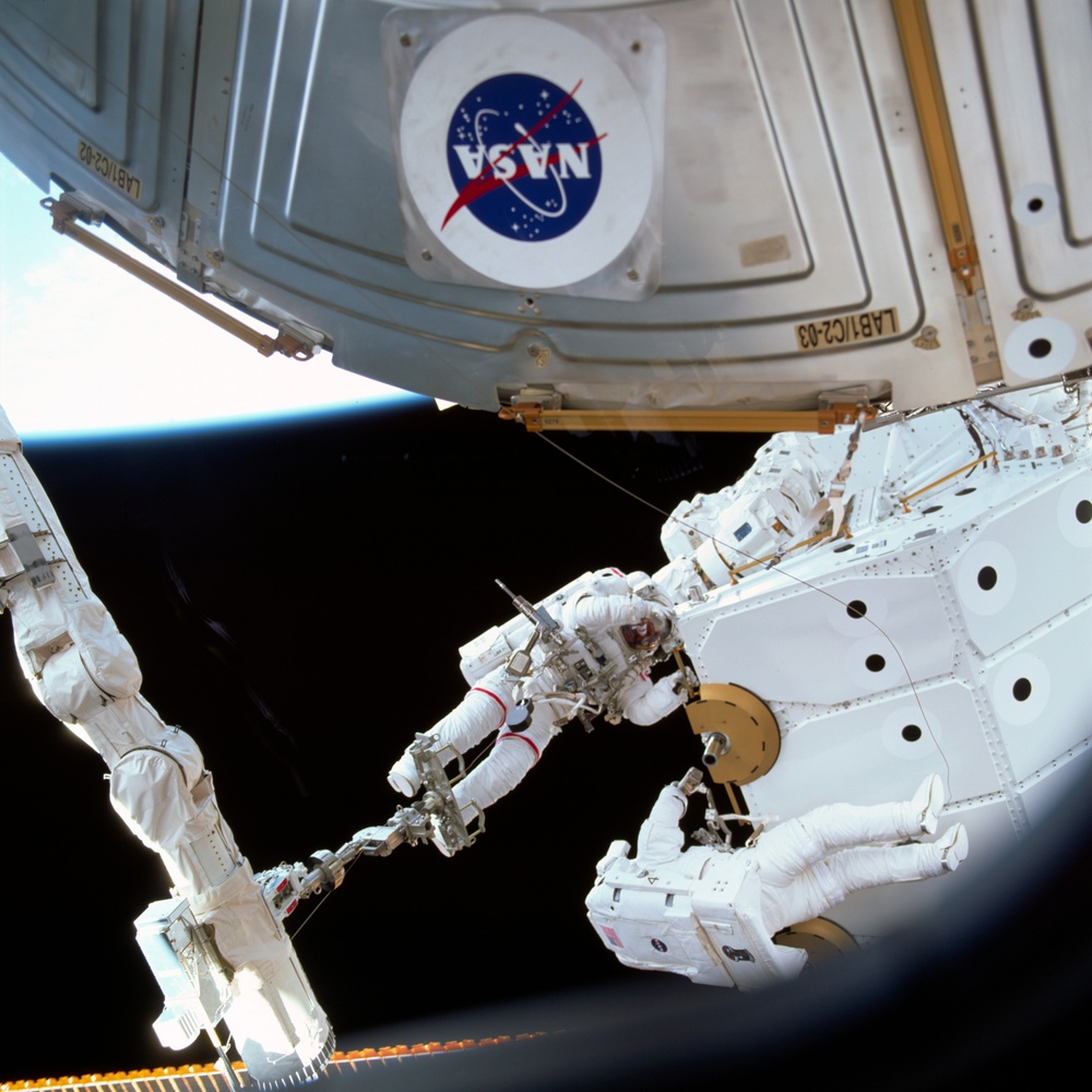 MS Hadfield and MS Parazynski work on the SSRMS from the SLP during an EVA for STS-100