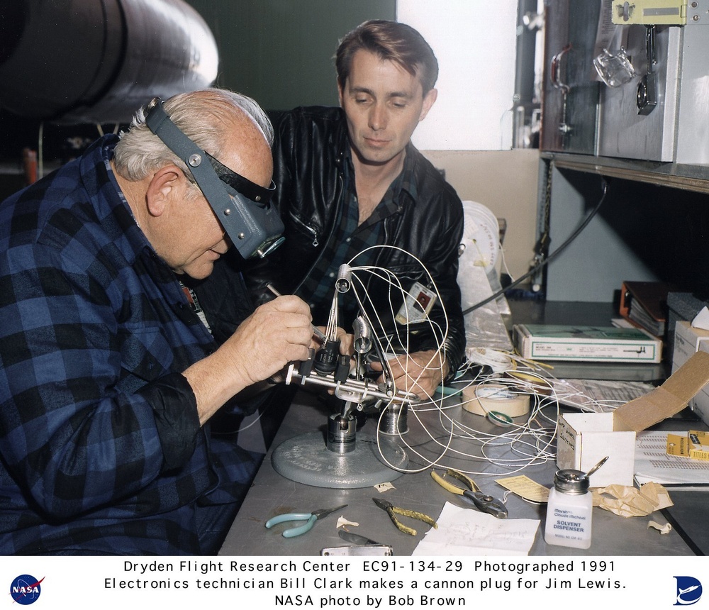 Electronics technician Bill Clark assembling a cannon plug with the help of Jim Lewis