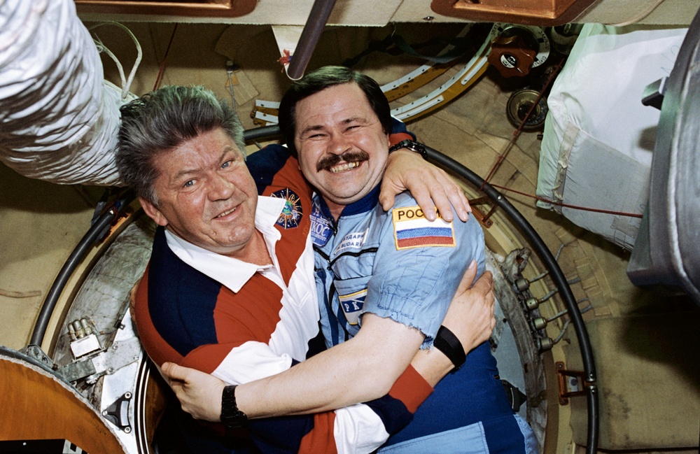 STS-91 crew is greeted at the hatch by Mir 25 crewmembers