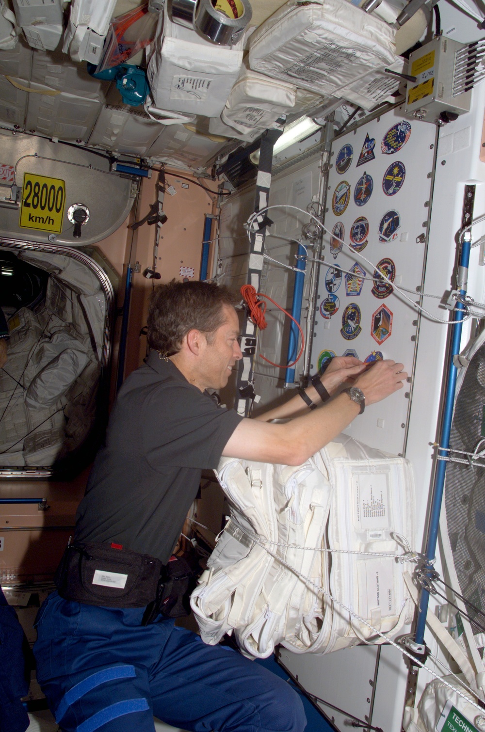 Wetherbee places mission sticker on panel in Node 1 during STS-113 / EXP. 5