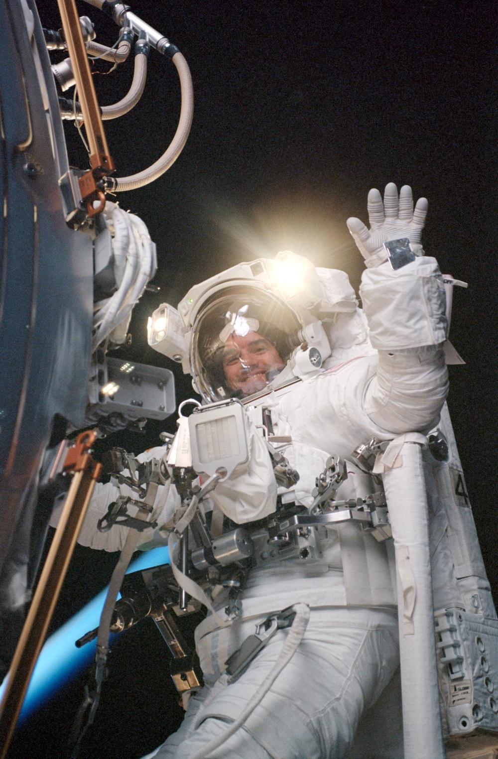 MS Walheim works with a Forward Avionics Umbilical during the first EVA of STS-110