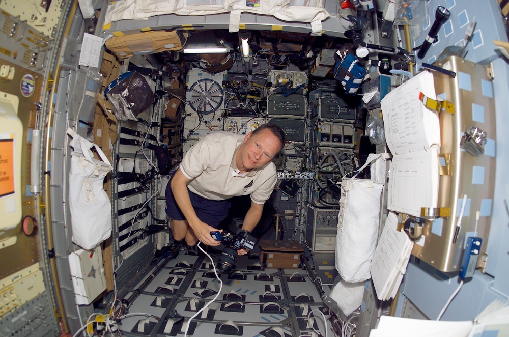 Brown holds a camera and microphone in the SH during STS-107
