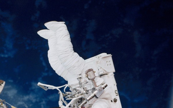 Helms translating along the payload bay sill during an EVA