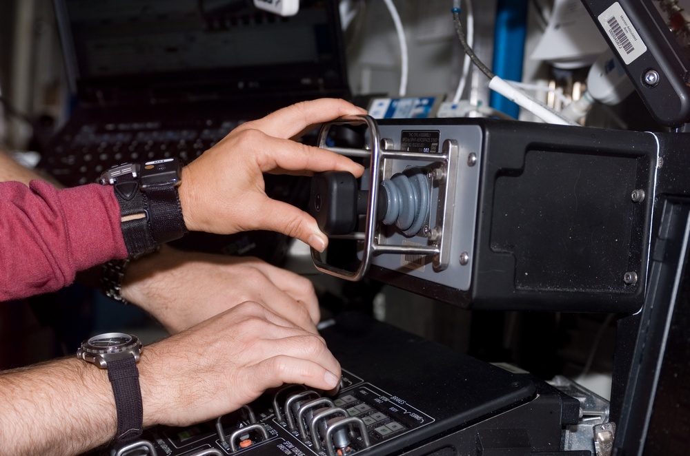 Lawrence and Kelly's hands on controls in the Destiny laboratory module