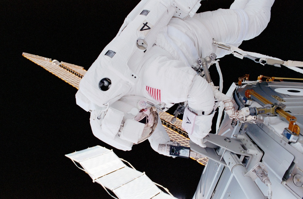 MS Parazynski drives in a bolt for the UHF antenna on Destiny during the first EVA of STS-100