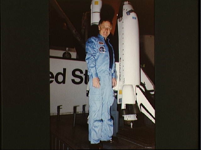 Portrait of Astronaut Don L. Lind posing with Shuttle model in bldg 9A