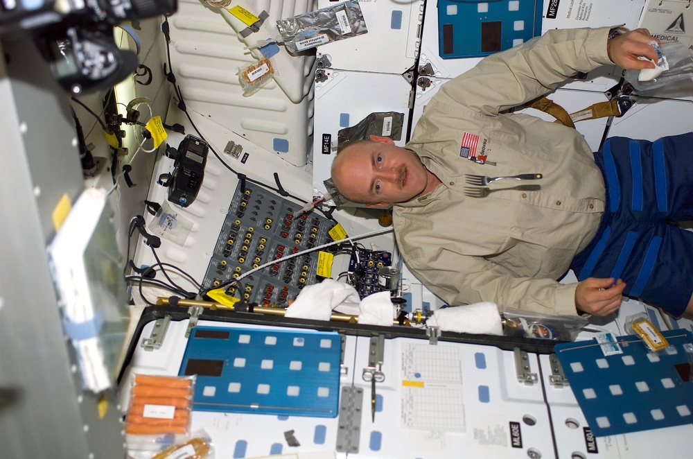 Kelly allows a fork to drift on the middeck during STS-108