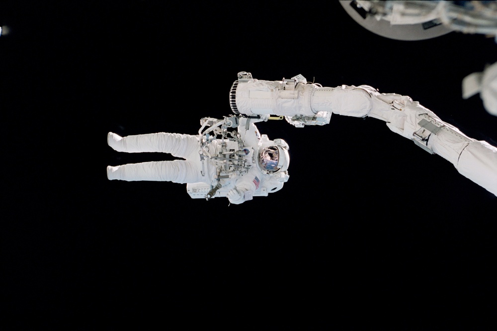 McArthur holds onto the RMS arm during EVA