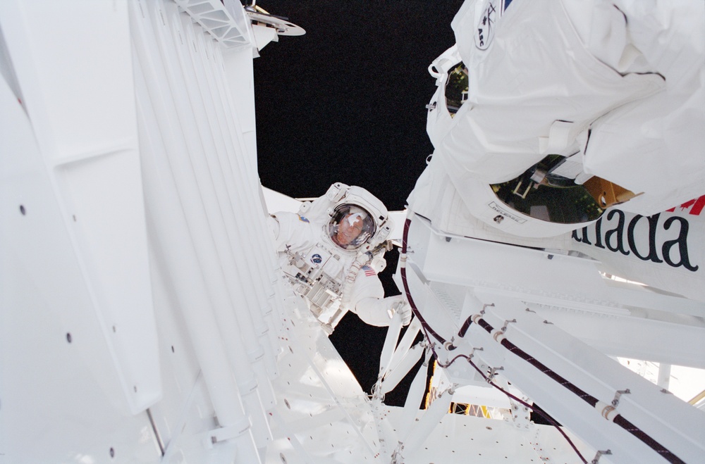 MS Parazynski helps raise the SSRMS from the SLP during the first EVA of STS-100