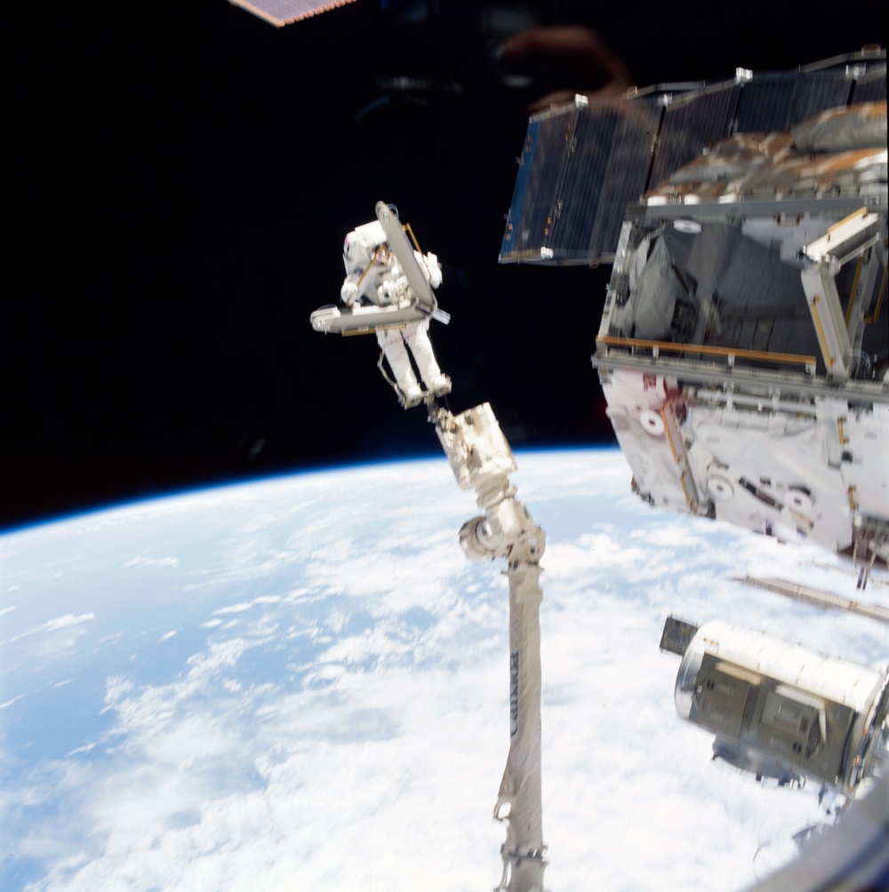 Morin handles a keel pin and is moved by the SSRMS during the second EVA of STS-110
