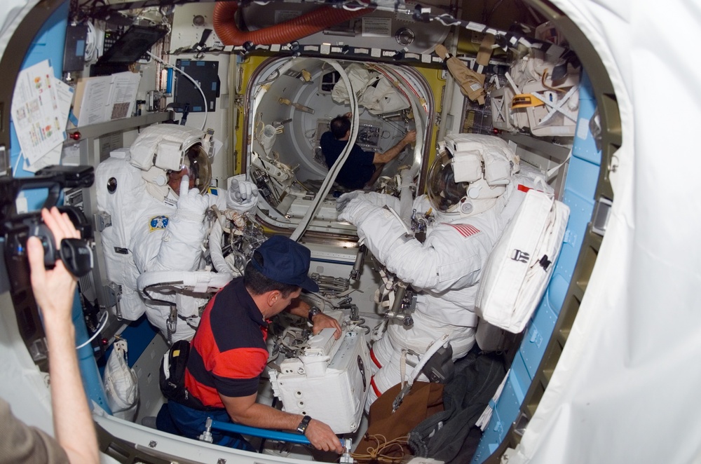 STS-116 MS Fuglesang and Curbeam wearing EMUs in the A/L during Joint Operations