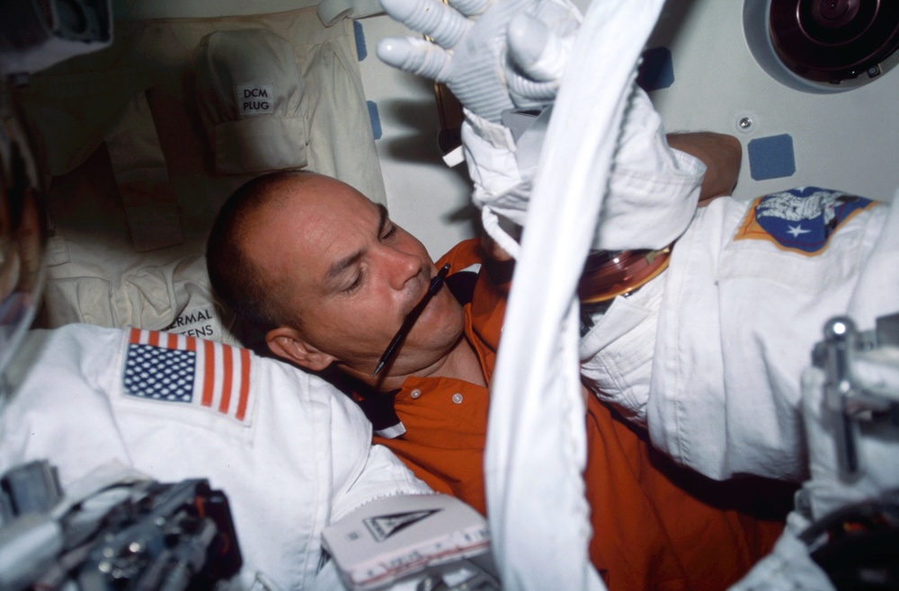 Sturckow assists EVA guys in the airlock