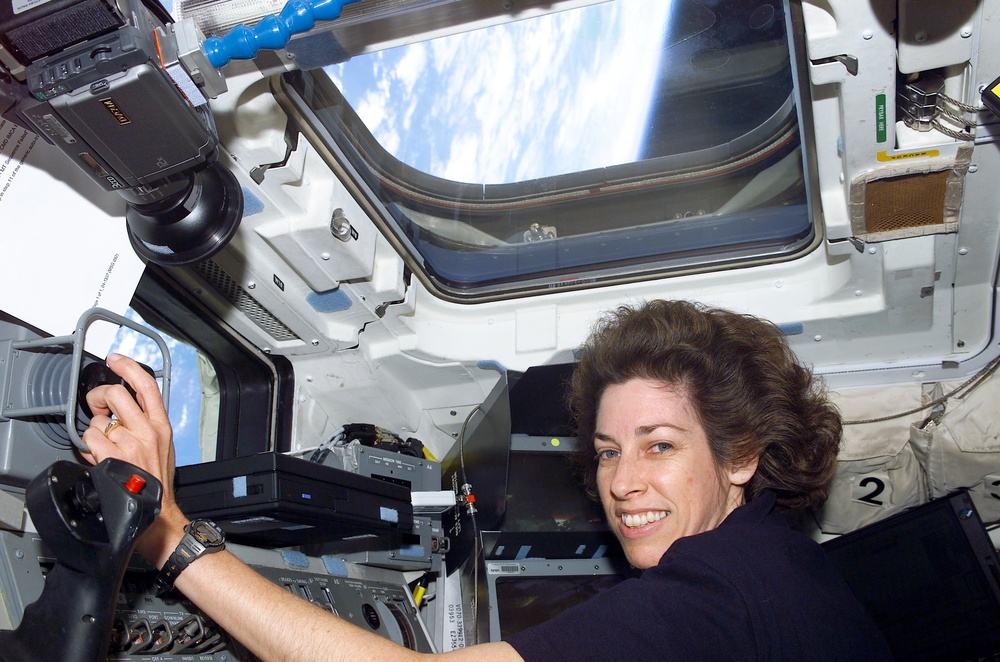 Ochoa works at the RMS controls on the flight deck of Atlantis during STS-110