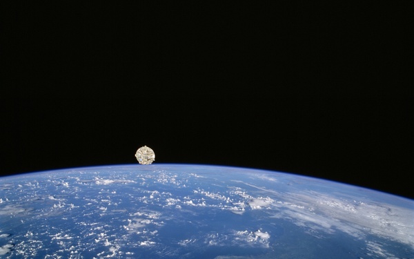 Wake Shield Facility in orbit above the Earth