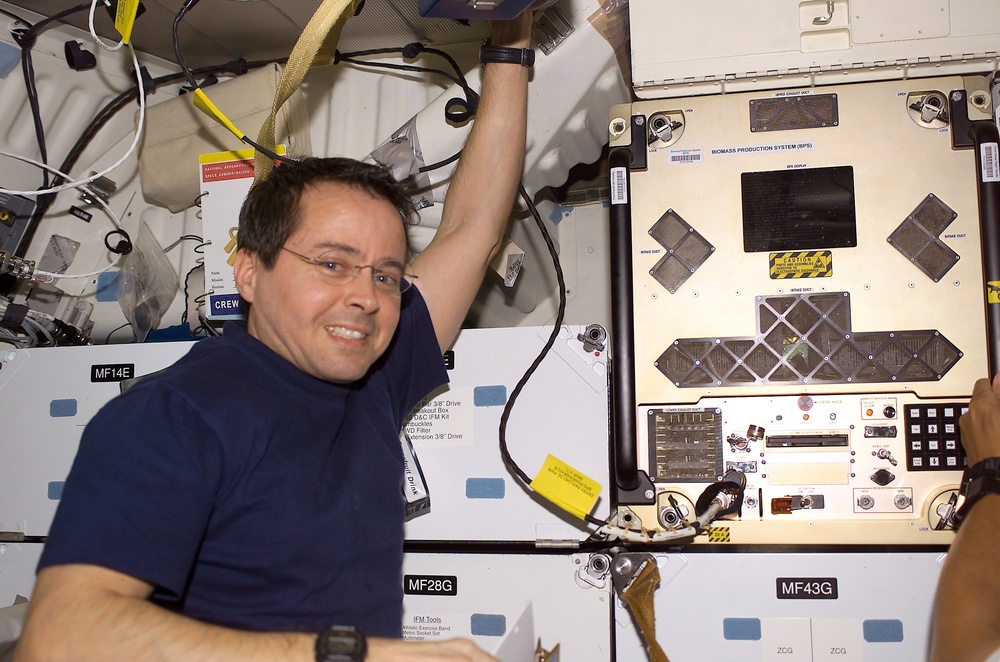 Bursch poses next to BPS installed in a slot on Endeavour's middeck for return on STS-111 UF-2
