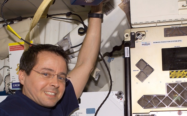 Bursch poses next to BPS installed in a slot on Endeavour's middeck for return on STS-111 UF-2
