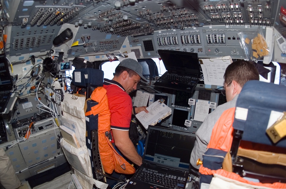 STS-116 Crewmembers looks at crew procedures in the FD on Space Shuttle Discovery
