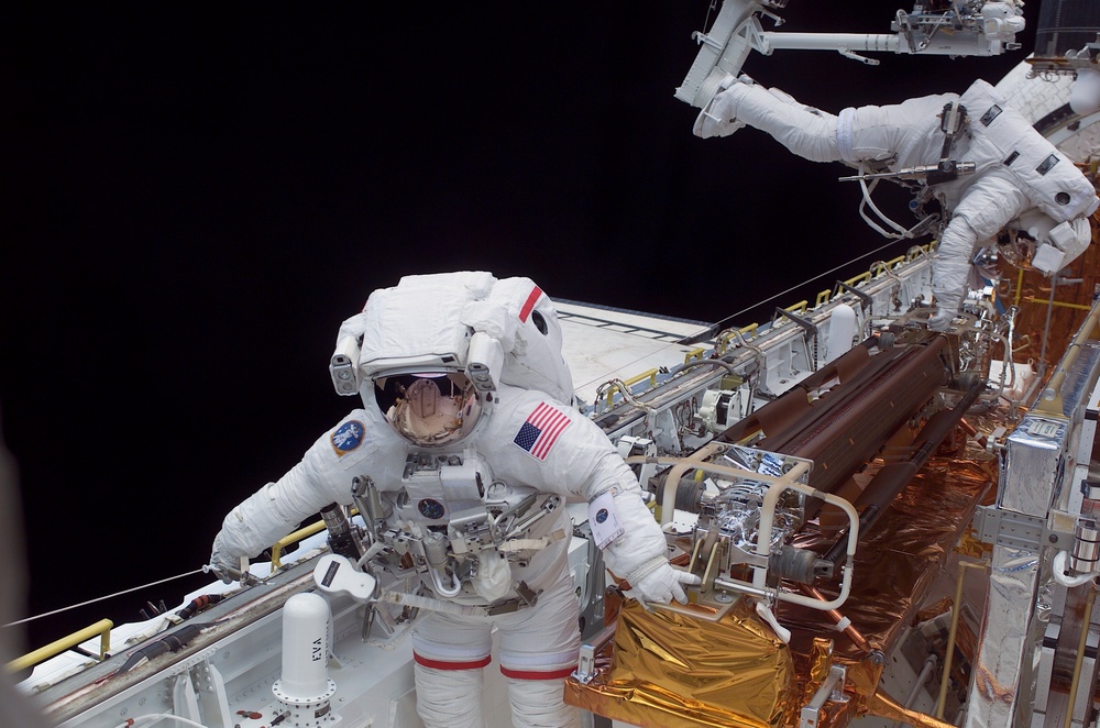 STS-109 MS Grunsfeld and Linnehan stow old solar array from payload bay