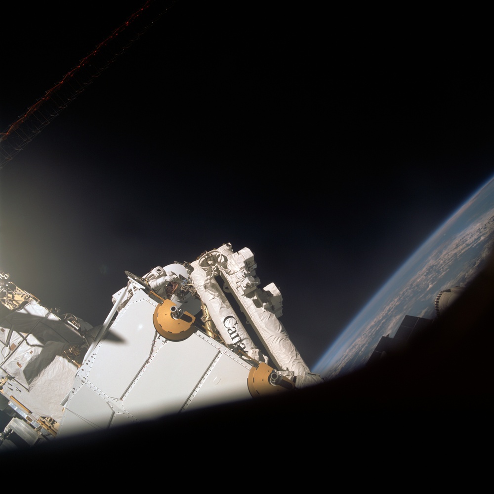 MS Parazynski works on the SSRMS from the SLP during an EVA for STS-100