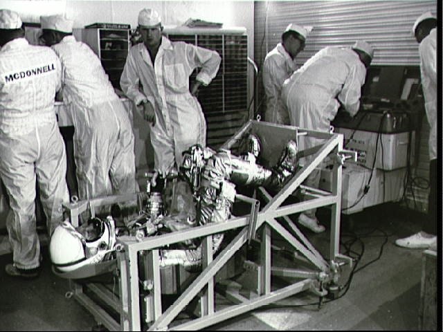 Astronaut L. Gordon Cooper on weight and balance scale