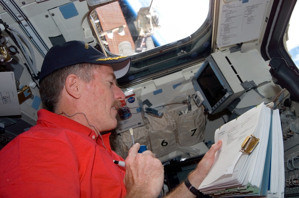 Reilly uses communication equipment in the aft FD on Space Shuttle Atlantis during Joint Operations