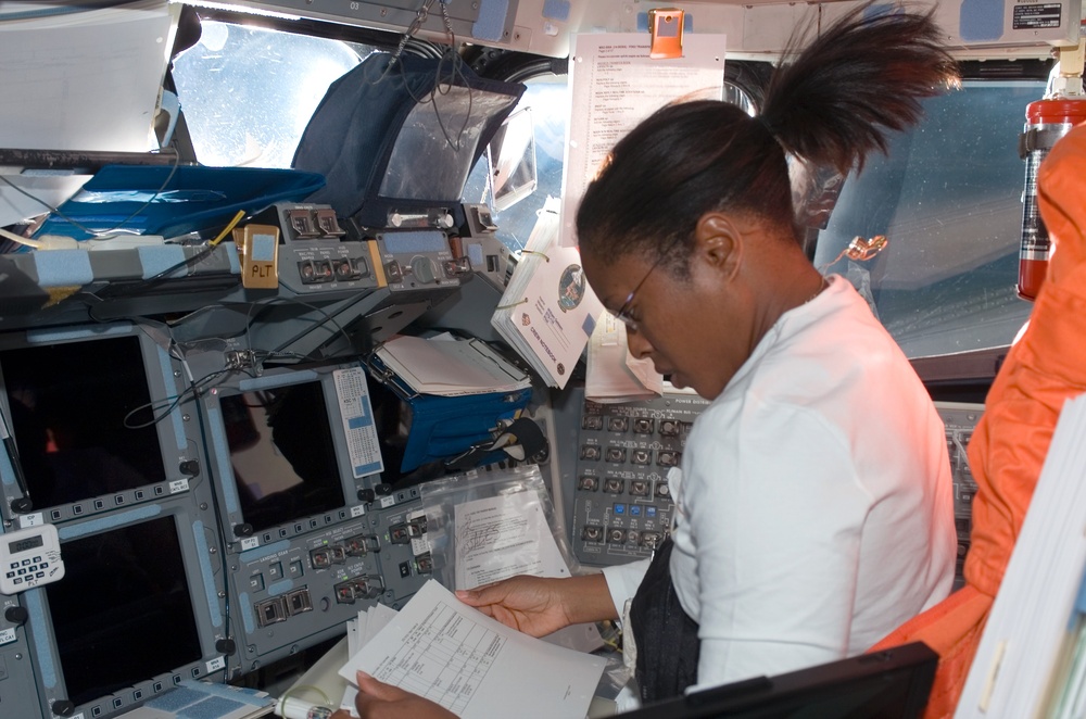 STS-116 MS Higginbotham looks at crew procedures at the FD console on Space Shuttle Discovery