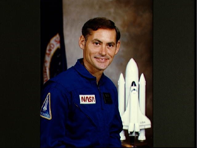 Portrait of Astronaut candidate Richard M. Mullane in blue flight suit.