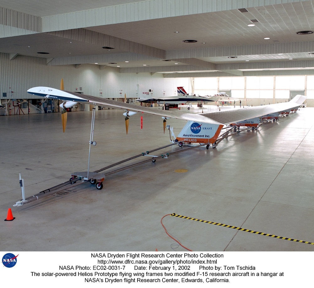 The solar-powered Helios Prototype flying wing frames two modified F-15 research aircraft in a hanga