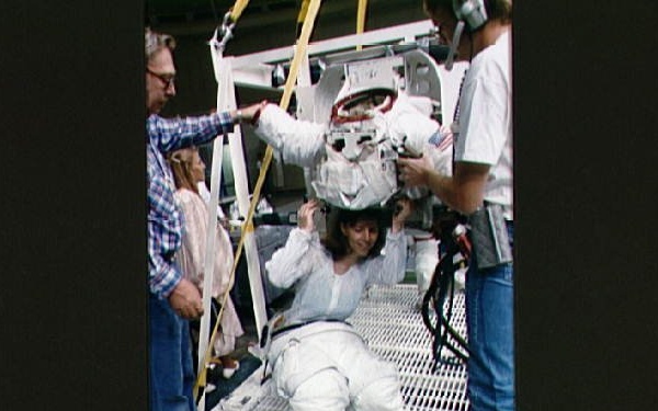 STS-32 MS Dunbar, wearing LCVG, dons EMU upper torso prior to WETF exercises