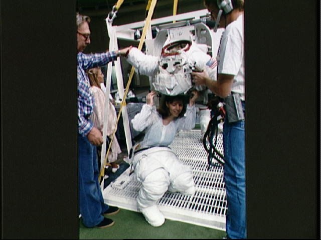 STS-32 MS Dunbar, wearing LCVG, dons EMU upper torso prior to WETF exercises