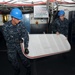 Sailors carry watertight door during ship refurbish