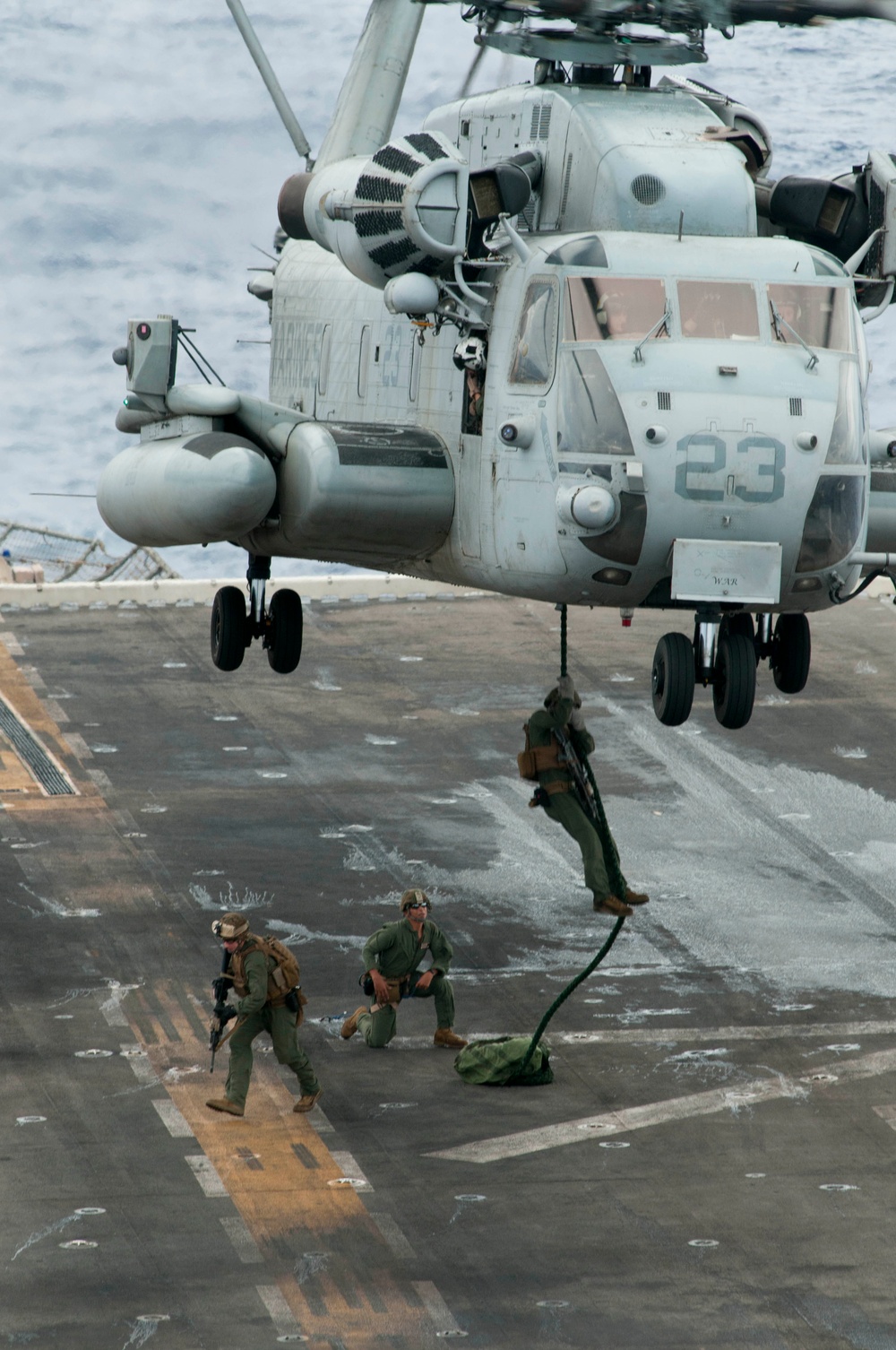 Marines fast rope onto flight deck of USS Peleliu