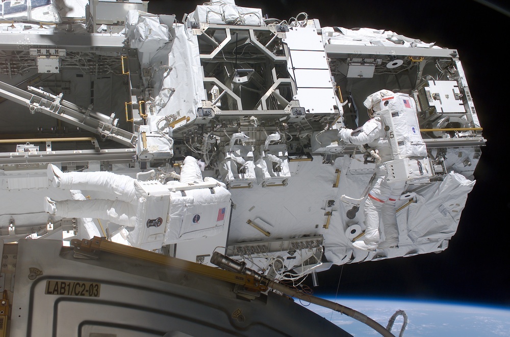 Walheim and Smith work on the Mobile Transporter during the third EVA of STS-110