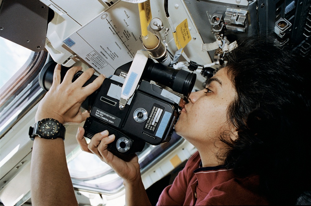 Chawla poses in front of flight deck windows