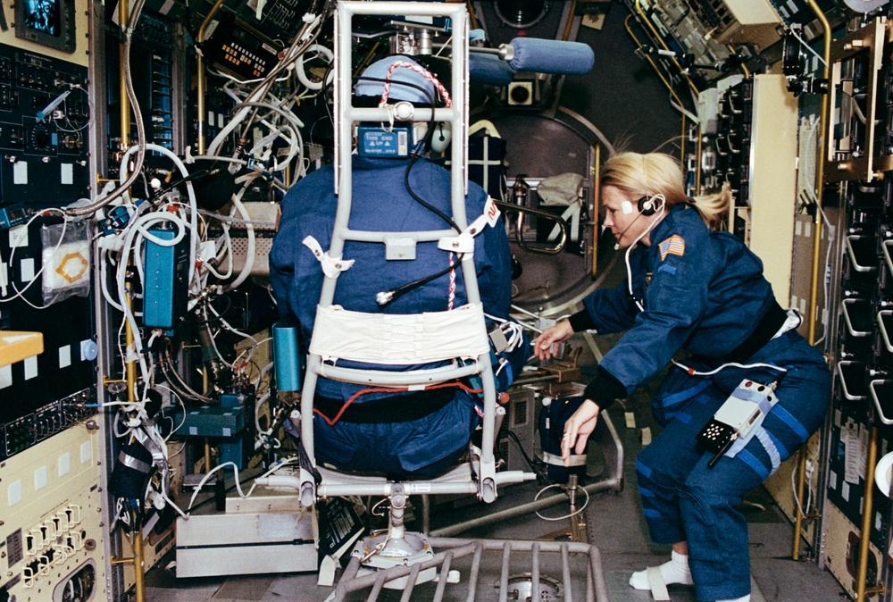 Crewmember in SPACELAB wearing the Acceleration Recording Unit and Collar.