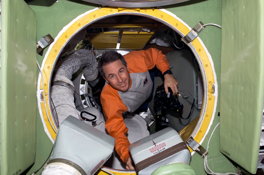 Robinson with camera in hatch leading to FGB