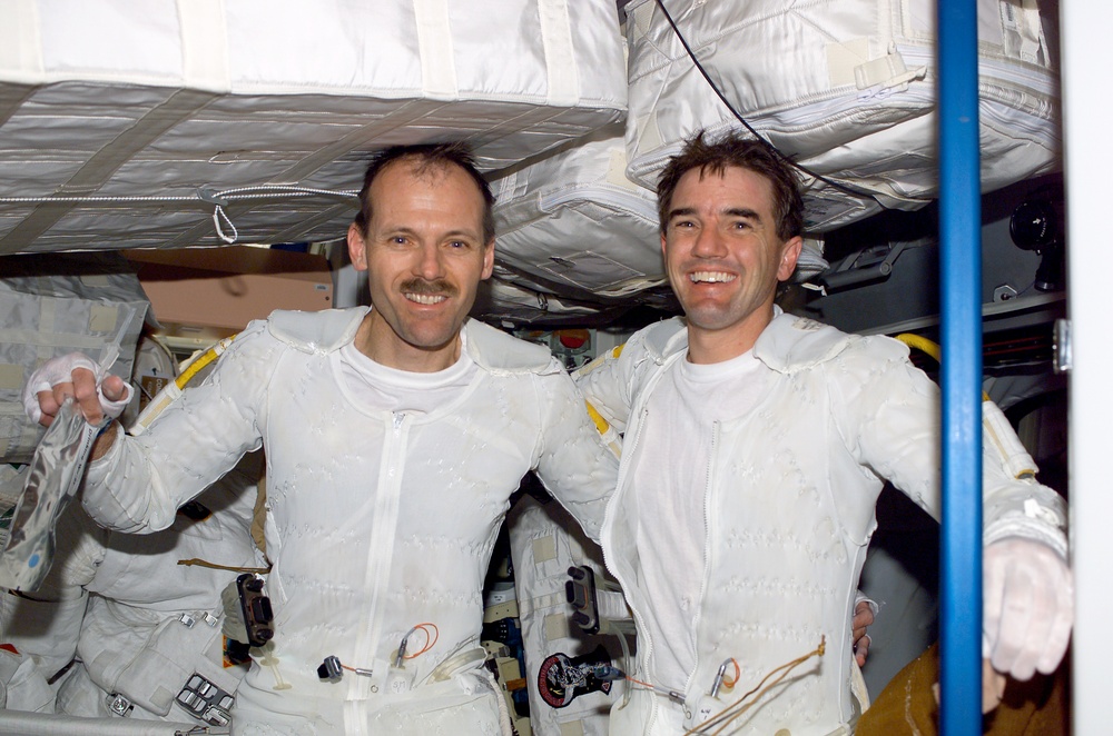 Walheim and Smith pose arm-in-arm in Node 1 after completing the first EVA for STS-110