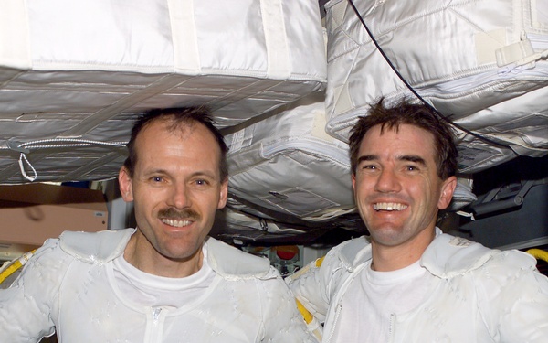 Walheim and Smith pose arm-in-arm in Node 1 after completing the first EVA for STS-110