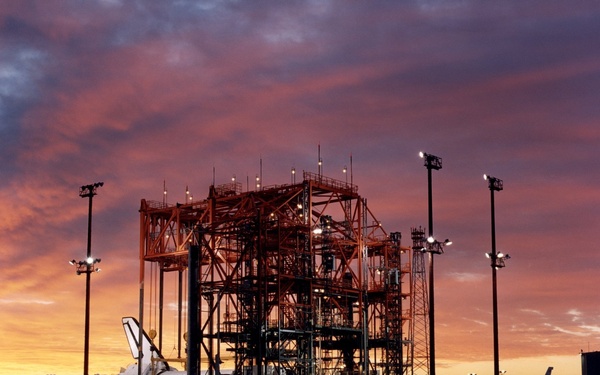 STS-92 - Orbiter in Mate-Demate Device (MDD) at sunrise with Shuttle Carrier Aircraft (SCA) in backg