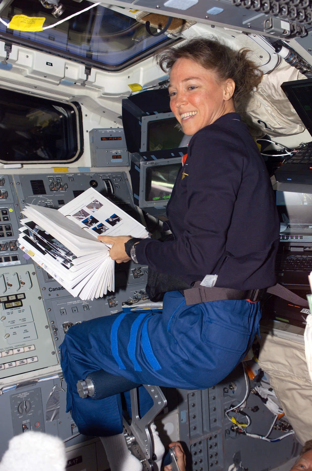 Nowak reads a checklist during OBSS berthing operations on STS-121
