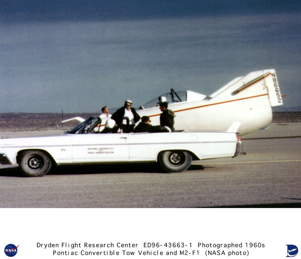 M2-F1 on lakebed with Pontiac convertible tow vehicle