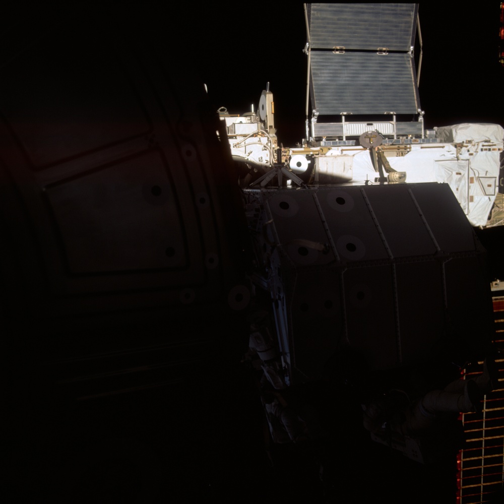 MS Hadfield and MS Parazynski work on the SSRMS from the SLP during an EVA for STS-100