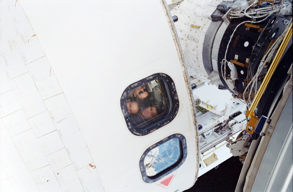 View of the STS-110 crewmembers in a window taken during the fourth EVA