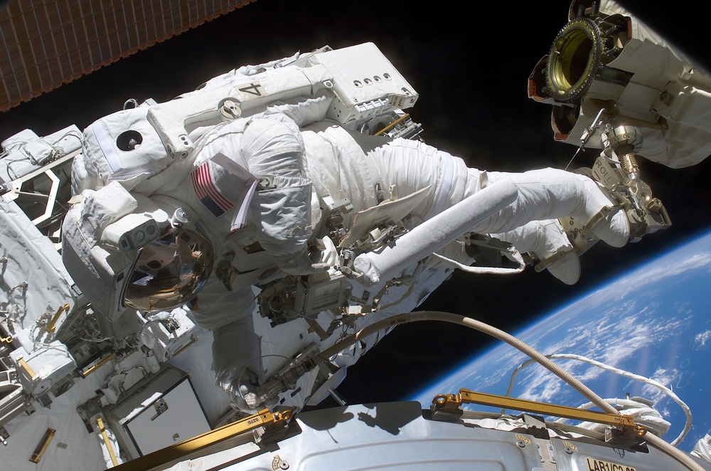 Walheim works with umbilicals by the U.S. Laboratory during the first EVA of STS-110