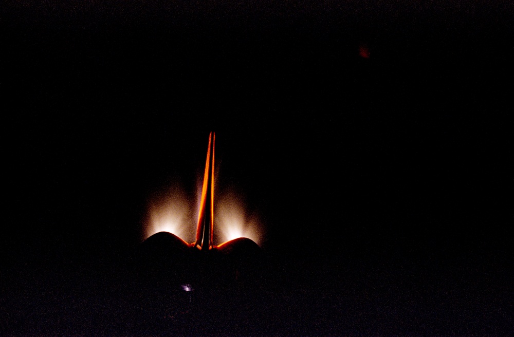 View of OMS burn and illuminated orbiter stabilizer