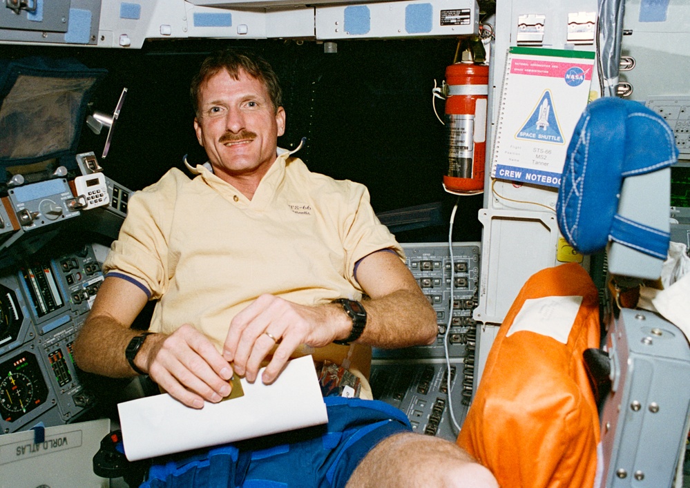 MS Tanner folds a paper at Atlantis' pilot station during STS-66