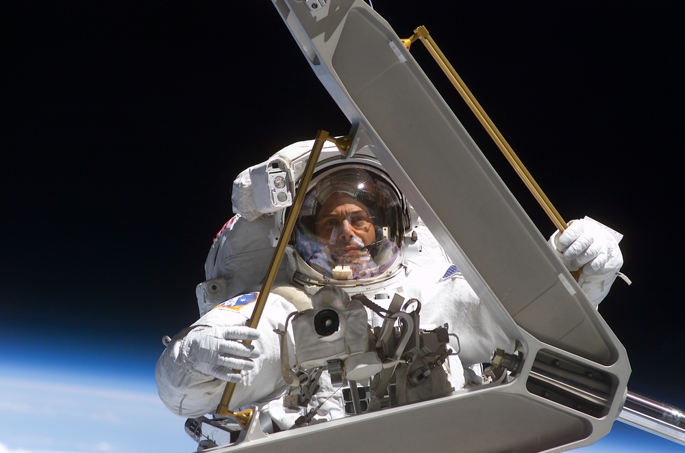 Morin handles a keel pin and is moved by the SSRMS during the second EVA of STS-110
